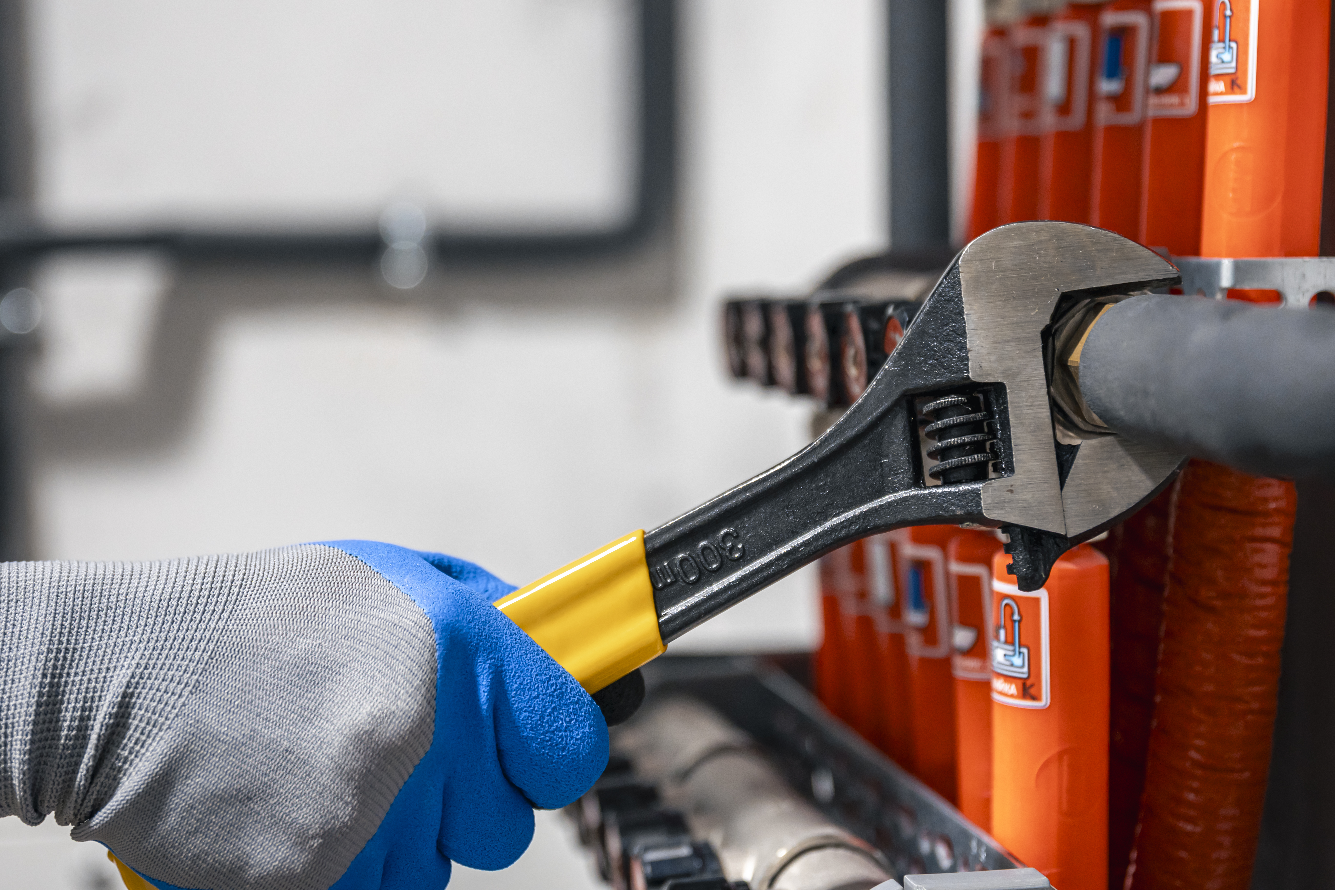 Plumber tightening pipe valves with a wrench